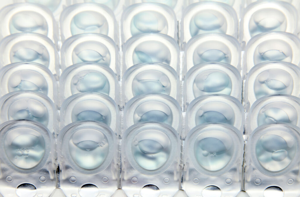 A stack of plastic contact lens containers.